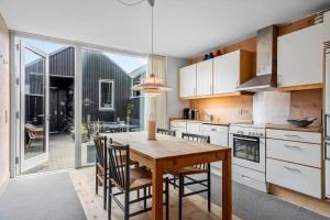 a kitchen with a wooden table and chairs and a large window at 733-Hvide-Sande-Slusen-33 in Hvide Sande