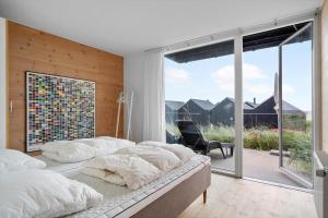 a bedroom with two beds and a large window at 733-Hvide-Sande-Slusen-33 in Hvide Sande