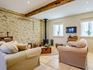 a living room with two couches and a stone wall at 2 Bed in Bridport oc-dc081 in Loders