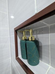 a green soap dispenser on a shelf in a bathroom at Jati Rinjani Tetebatu in Tetebatu