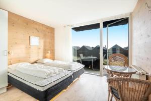 a bedroom with a bed and a balcony with a table at 727-Hvide-Sande-Slusen-27 in Hvide Sande