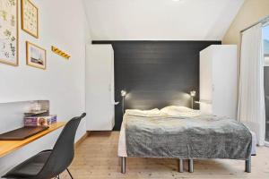 a bedroom with a bed and a desk and a chair at 701-Hvide-Sande-Slusen-1 in Hvide Sande