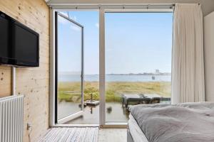 a bedroom with a large window with a view of the ocean at 701-Hvide-Sande-Slusen-1 in Hvide Sande