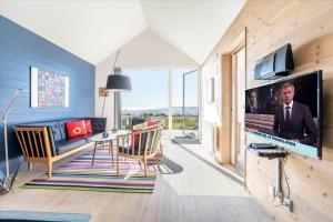 a living room with a large flat screen tv on a wall at 705-Hvide-Sande-Slusen-5 in Hvide Sande