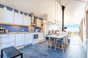 a kitchen with white cabinets and a table and chairs at 705-Hvide-Sande-Slusen-5 in Hvide Sande