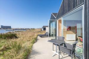a house with glass doors and a table and chairs at 705-Hvide-Sande-Slusen-5 in Hvide Sande