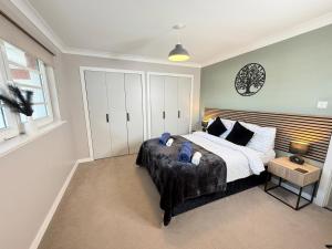 a bedroom with a large bed and a table at Bathgate Penthouse near Edinburgh in Bathgate