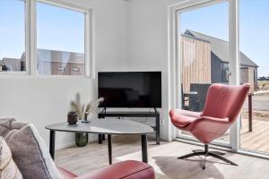 a living room with a pink chair and a table at 941-Hvide-Sande-Langsand-167 in Hvide Sande
