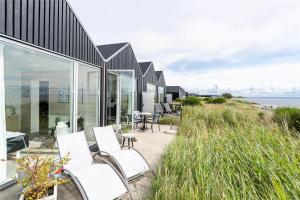 a house on the beach with white chairs at 706-Hvide-Sande-Slusen-6 in Hvide Sande