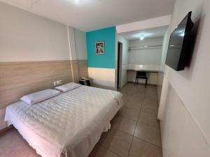 a bedroom with a bed and a desk and a television at Village Hotel Belém in Belém de São Francisco
