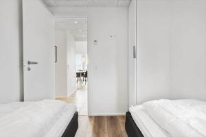 two beds in a room with white walls at 948-Hvide-Sande-Langsand-226 in Hvide Sande