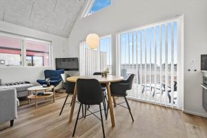 a dining room and living room with a table and chairs at 948-Hvide-Sande-Langsand-226 in Hvide Sande