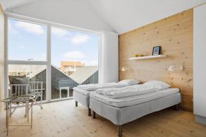 a bedroom with two beds and a large window at 723-Hvide-Sande-Slusen-23 in Hvide Sande
