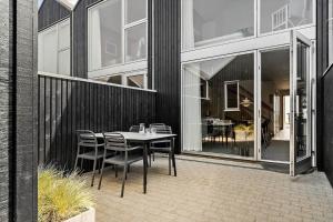 a patio with a table and chairs in front of a building at 723-Hvide-Sande-Slusen-23 in Hvide Sande