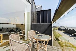 a patio with a table and chairs on a balcony at 722-Hvide-Sande-Slusen-22 in Hvide Sande
