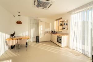 a kitchen with a wooden table and a dining room at Titine Apartment in Srithanu