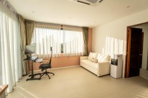 a living room with a couch and a chair and window at Titine Apartment in Srithanu
