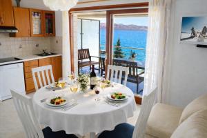 a dining table with a white table cloth and wine glasses at Apartmani Ribarica**** in Karlobag