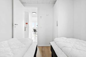 a bedroom with white walls and a white bed at 946-Hvide-Sande-Langsand-224 in Hvide Sande