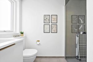 a white bathroom with a toilet and a shower at 946-Hvide-Sande-Langsand-224 in Hvide Sande +25 photos