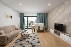 a living room with a couch and a tv and a table at Athina Suites Hotel in Bucharest