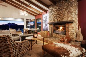 a living room with a large stone fireplace at Elephant Hide of Knysna Guest Lodge in Knysna