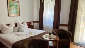 a hotel room with a bed and two chairs at Kőnig apartman in Hévíz