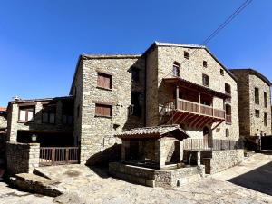 a large brick building with a porch and a balcony at Cal Grit casa de muntanya a Pont de Bar in Bar
