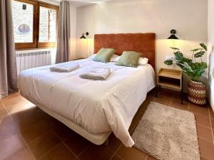 a bedroom with a large bed with towels on it at Cal Grit casa de muntanya a Pont de Bar in Bar