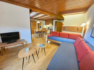 a living room with a blue couch and a tv at Alpenlandhof in Bad Kleinkirchheim
