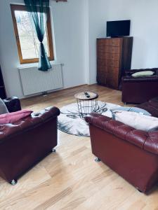 a living room with two leather couches and a table at Ferienhaus am Reisberg in Reisberg