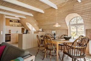 a kitchen and dining room with a table and chairs at 505-Hvide-Sande-Riskrogvej-12 in Havrvig