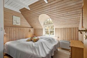 a bedroom with a dog laying on a bed at 505-Hvide-Sande-Riskrogvej-12 in Havrvig
