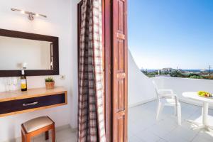 a room with a balcony with a table and a mirror at Casa Garden in Karpathos
