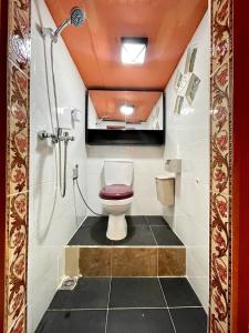 a small bathroom with a toilet and a shower at Backpackers Cabin with Mountain View in Bedugul +76 photos