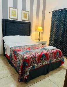 a bedroom with a large bed with a colorful blanket at Hostal Rio Piedra in Estelí