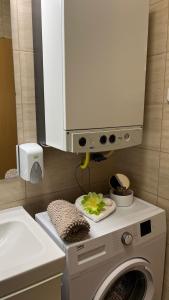 a washing machine with a cabinet above it in a bathroom at Kőnig apartman in Hévíz