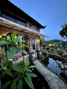 a villa with a pool in front of a house at Backpackers Cabin with Mountain View in Bedugul