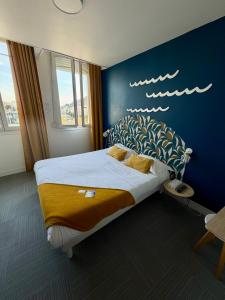 a bedroom with a large bed with a blue wall at La Marinière Hôtel Restaurant in Saint Malo