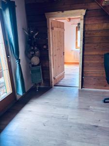 an open door in a room with wooden walls at Ferienhaus am Reisberg in Reisberg +3 photos