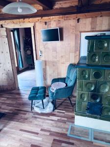 a living room with a fireplace and a chair and a television at Ferienhaus am Reisberg in Reisberg