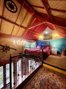 an attic room with a staircase in a house at Backpackers Cabin with Mountain View in Bedugul