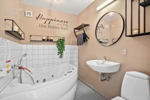 a bathroom with a tub and a sink and a toilet at 7716-Hvide-Sande-Slusen-16 in Hvide Sande +36 photos
