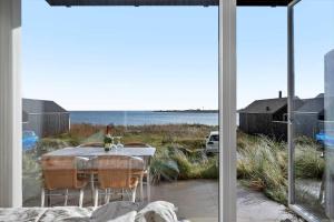 a table and chairs on a patio with a view of the ocean at 7716-Hvide-Sande-Slusen-16 in Hvide Sande
