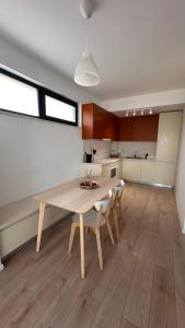 a kitchen with a wooden table and chairs in a room at Warm apartament 3 in Bucharest