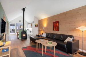 a living room with a leather couch and a fireplace at 745-Hvide-Sande-Slusen-45 in Hvide Sande
