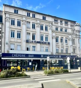 a large white building with a bar in front of it at La Marinière Hôtel Restaurant in Saint Malo
