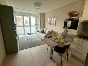 a kitchen and living room with a table and a couch at Apartamento Cimadevilla Plaza in Oviedo