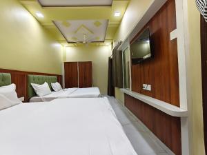 a hotel room with two beds and a tv at Hotel Ajmer Pride in Ajmer +15 photos