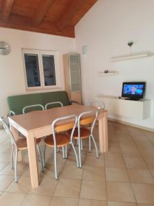 a dining room with a wooden table and chairs at Dimora sul mare in Policoro